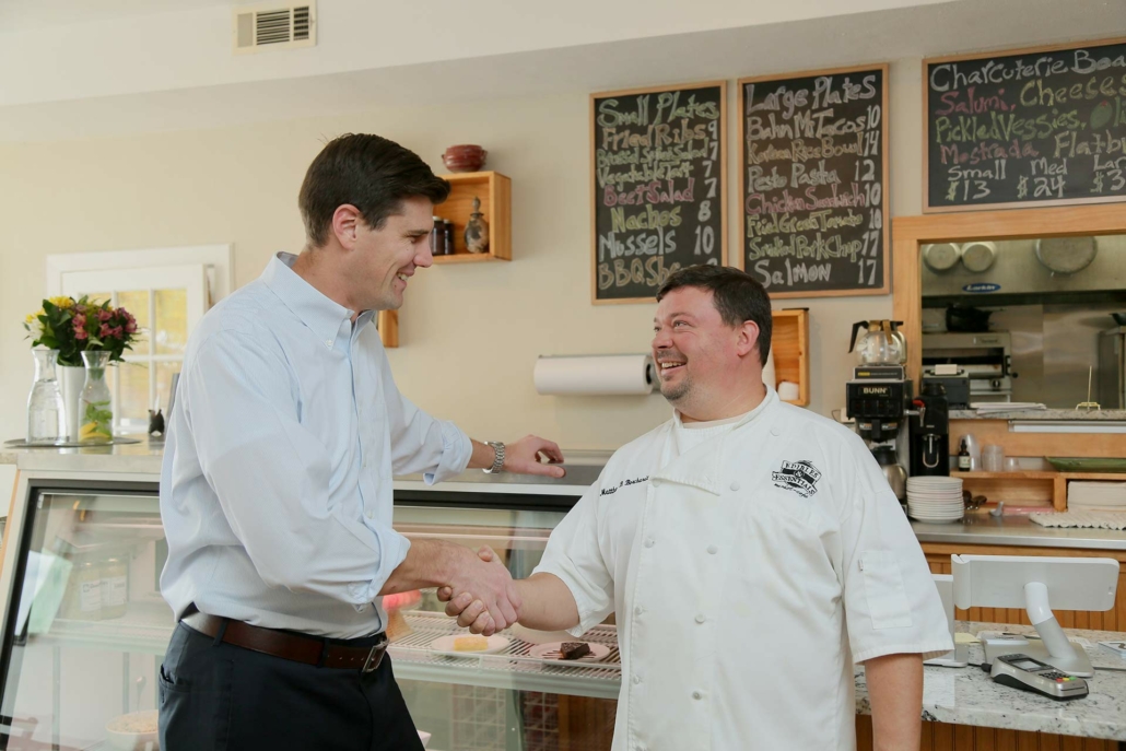 Tom Oldenburg shaking hands with St. Louis business owner